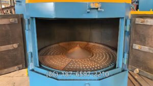 turntable shot blasting machine (also called a rotary table shot blasting machine) is a surface-cleaning and strengthening equipment used in foundries, machining workshops, and metal fabrication plants. It uses a rotating table to hold the workpieces while high-speed steel shots are blasted onto the surface by one or more blast turbines.